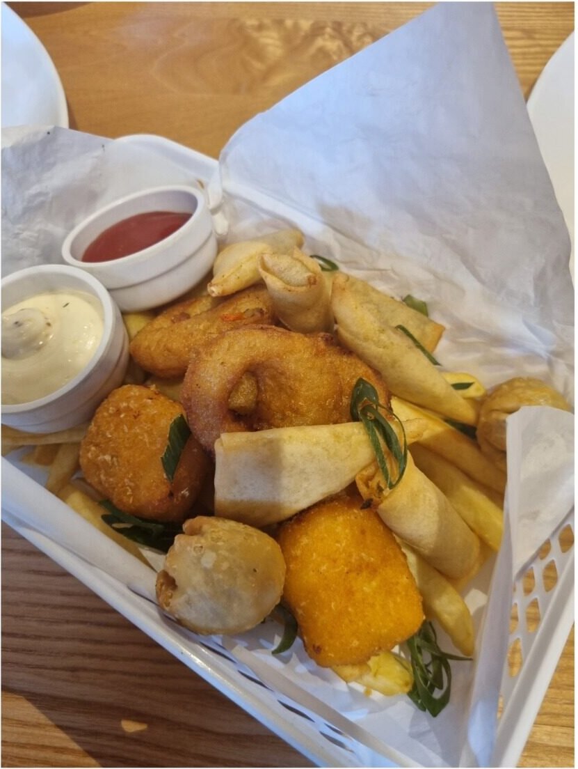 Bar basket of spring rolls, onion rings and fries